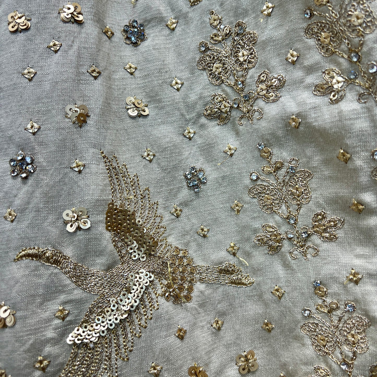 Intricate embroidery detail on an ivory bridal lehenga from JMS Studio featuring floral and bird motifs