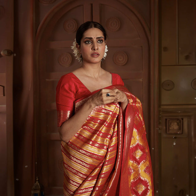Red silk saree with gold zari stripes and embellished pallu