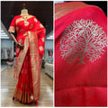 Red woven saree with golden zari border and ornate leaf motifs in silver tones