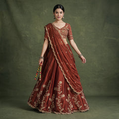 Rust embroidered lehenga choli with gold motifs and sequins, draped dupatta on model