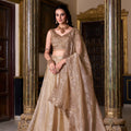 Beige sequined lehenga choli set with thread embroidery and ornate neckline, standing front