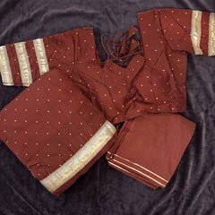 Flat lay of the maroon dotted skirt, blouse and dupatta with gold lace bands