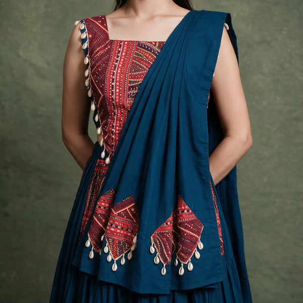 Close-up of the red printed blouse with cowrie trim and the navy dupatta with cowrie-trimmed red panels