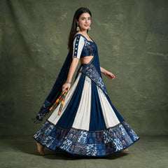Side view of the navy and white chaniya choli in a twirl, showing the printed indigo hem border and the dupatta trailing behind