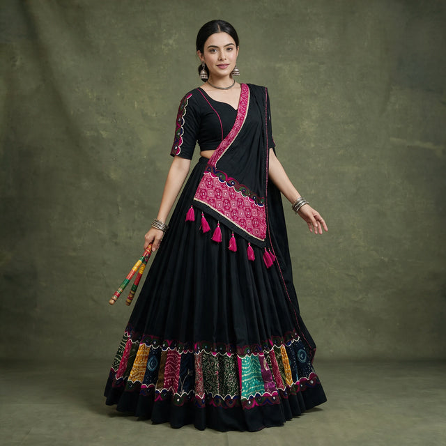 Model in a black khadi cotton chaniya choli with multicolour patchwork panels at the hem and a black dupatta with a pink bandhej-print panel and tassels