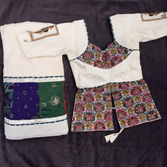 Flat lay of the ivory khadi cotton skirt with a multicolour patch border and the long ivory blouse with multicolour embroidery