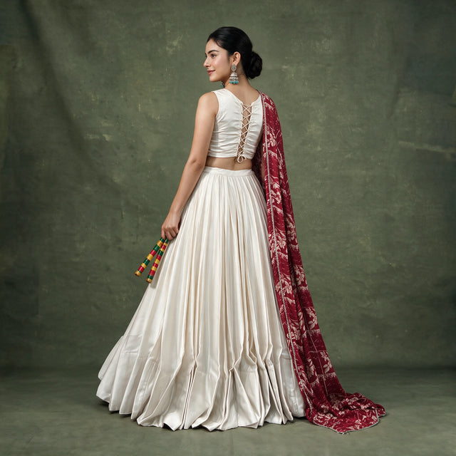 Back view of the ivory chaniya choli with tie-up blouse back and the maroon printed dupatta falling behind