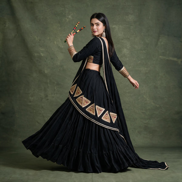 Side-back view of the black chaniya choli in a twirl, showing the gold triangular patches on the dupatta