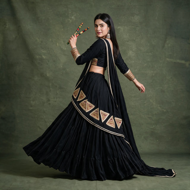 Side-back view of the black chaniya choli in a twirl, showing the gold triangular patches on the dupatta