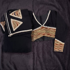 Flat lay of the black set: black dupatta with cream-edged gold triangular patches and the black blouse with a gold embroidered waist band and sleeve cuffs