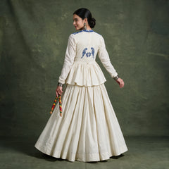 Back view of the ivory top with a blue embroidered bird motif and the tiered skirt