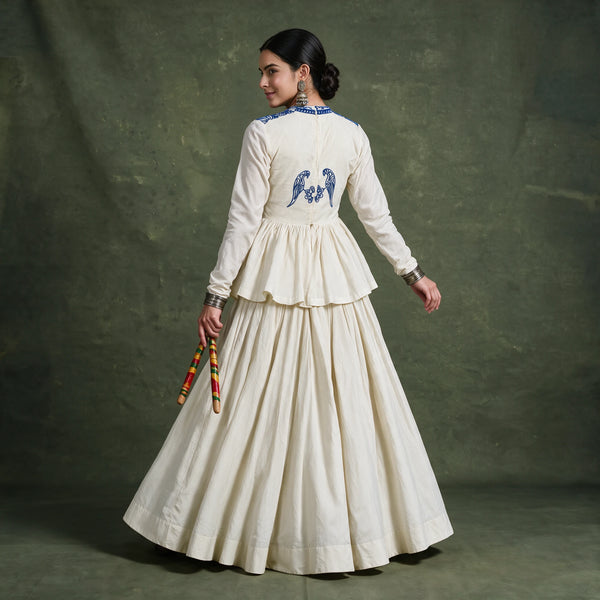 Back view of the ivory top with a blue embroidered bird motif and the tiered skirt