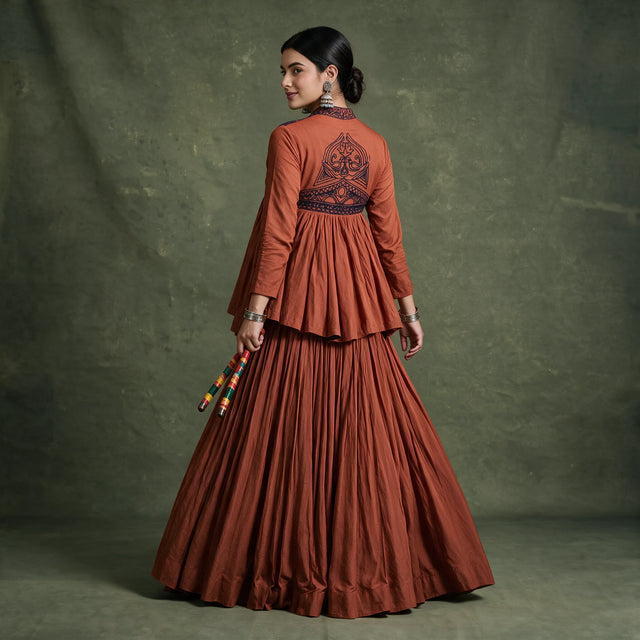 Back view of the rust top with a dark embroidered motif and the full rust skirt