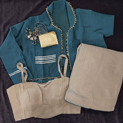 Flat lay of the teal jacket, beige top, beige skirt and the small gold purse