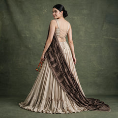 Beige pleated lehenga with lace-trimmed dark printed dupatta over satin choli
