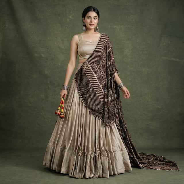 Beige satin choli with dark printed satin dupatta and pleated lehenga skirt