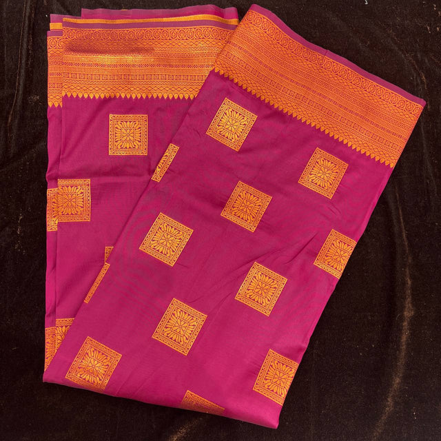 Pink silk saree folded flat with copper zari square motifs and wide patterned border