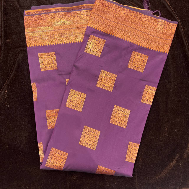 Purple silk saree folded flat with copper zari square motifs and wide border