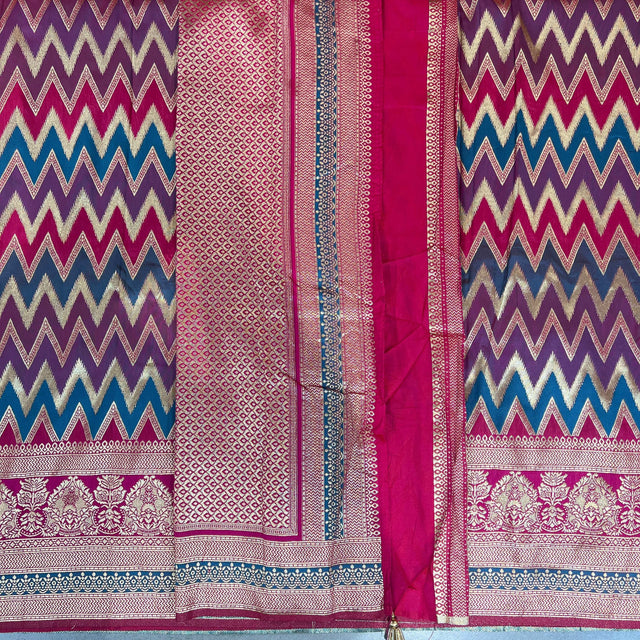 Rani pink and gold silk saree with zigzag chevron pattern and ornate silver border
