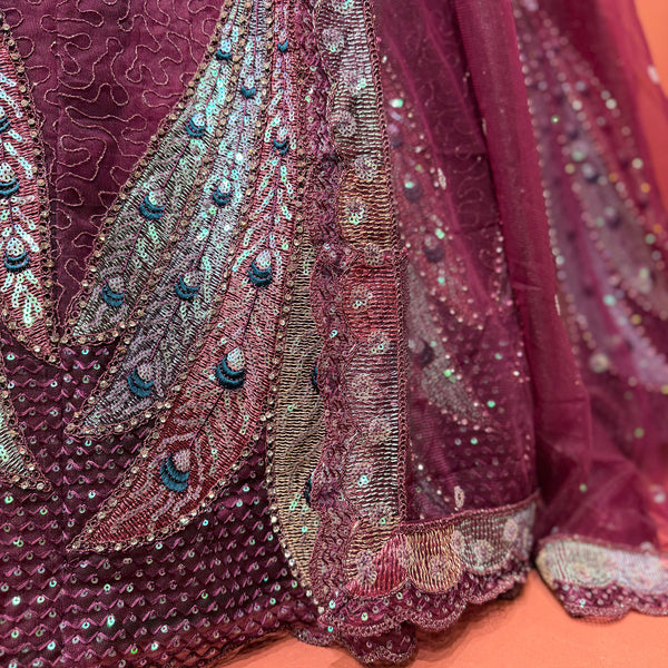 Wine peacock motif lehenga skirt close-up with sparkling sequins and beaded border