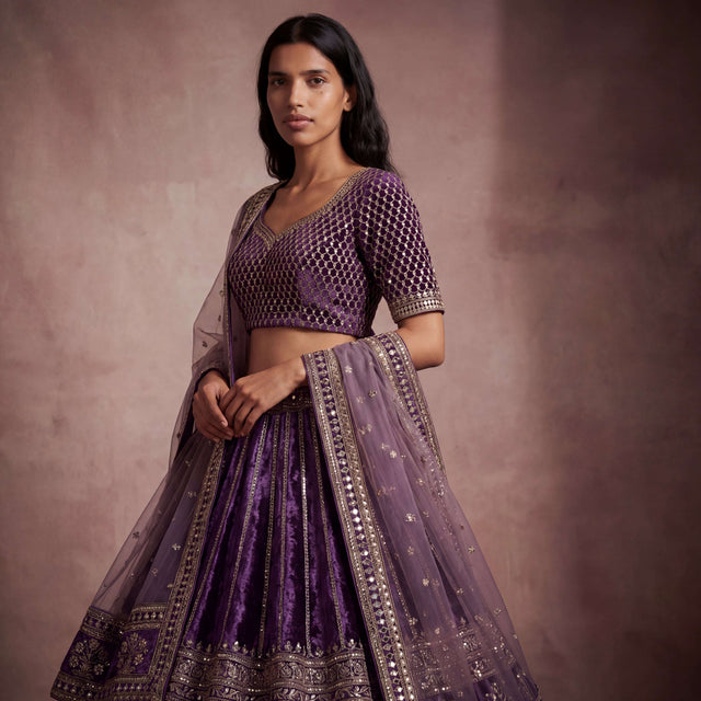 Purple velvet blouse and lehenga set with gold mirrorwork trim and sheer dupatta