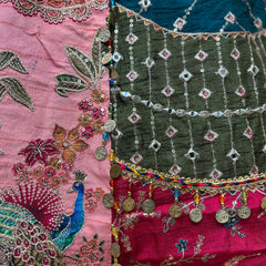 Close-up of embroidered lehenga skirt panel with teal, magenta, and bead fringe