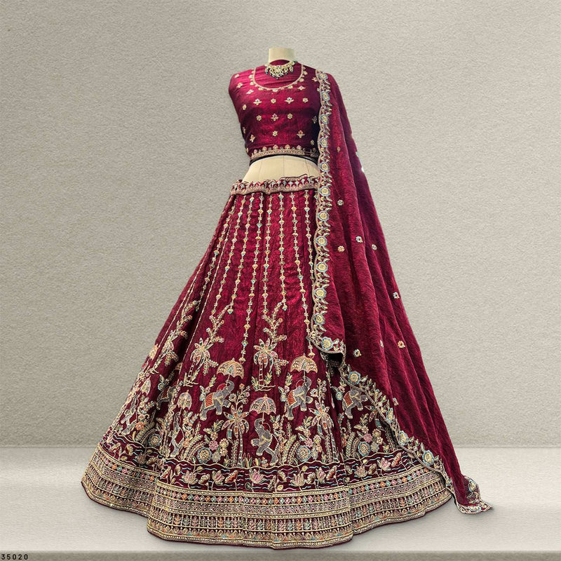Maroon tissue silk lehenga with gold border and ornate floral embroidery on skirt