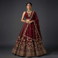 Maroon tissue silk lehenga with gold zari and floral embroidery, wide flared skirt