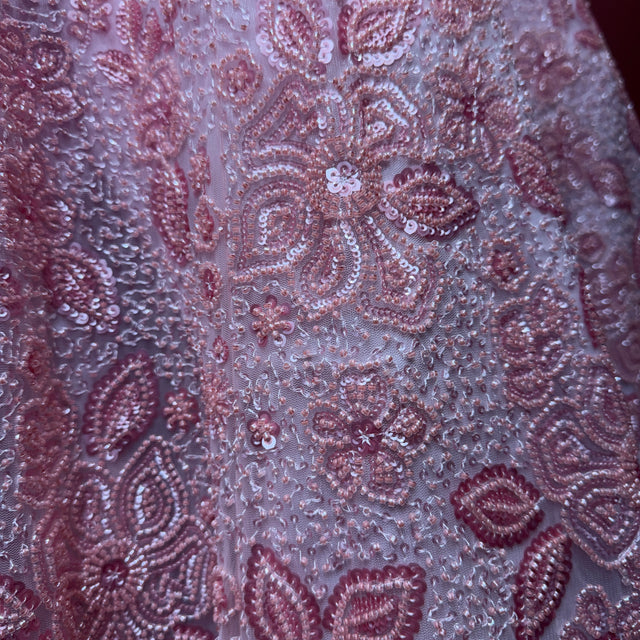 Close-up of lilac-pink cutdana and pearl floral embroidery with sequins on net fabric