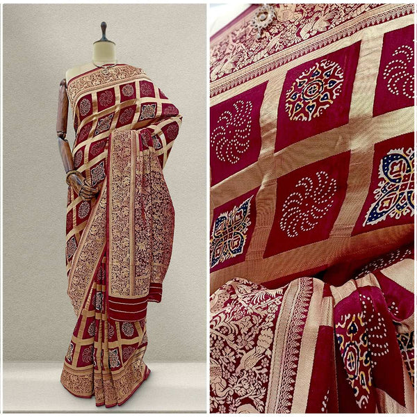 Maroon silk saree with gold weave, ornate border and geometric block pattern.