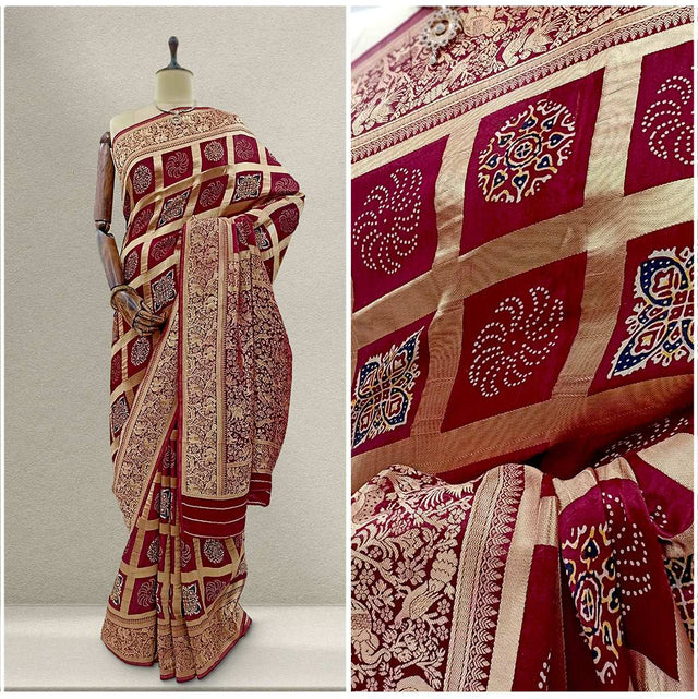 Maroon silk saree with gold weave, ornate border and geometric block pattern.