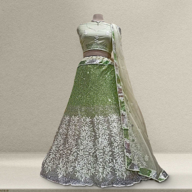 Green sequined lehenga with silver floral pattern hem and sheer net dupatta