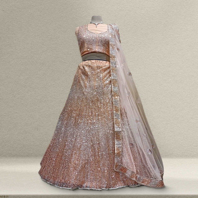 Peach sequined net lehenga with matching sheer dupatta and sleeveless bodice