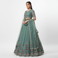 Teal-green lehenga set with round-neck blouse, flared skirt, and embroidered sheer dupatta