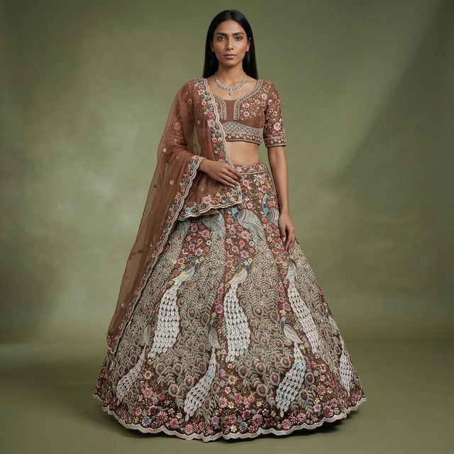 Model wearing rust peacock lehenga with embroidered blouse, full skirt, and dupatta