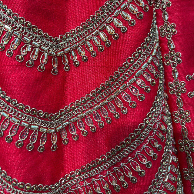 Red lehenga fabric detail with gold scalloped embroidery and chain trim