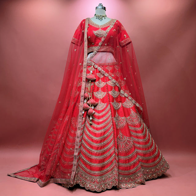 Red bridal lehenga with flared skirt, ornate silver embroidery, and two matching dupattas