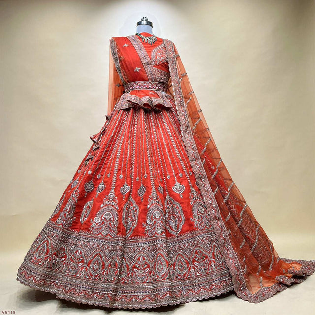 Rust orange bridal lehenga on mannequin with layered skirt and sheer dupatta