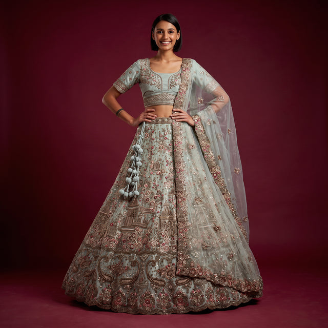 Sage green embroidered bridal lehenga set on model, with full skirt and sheer dupatta