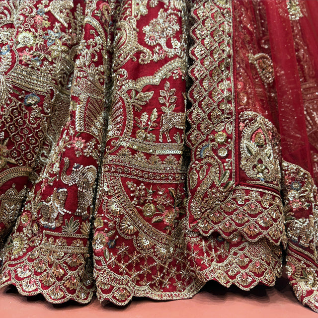 Cherry red lehenga skirt hem with dense gold zardosi-style embroidery and ornate motifs