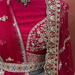 Close-up of the embroidered blouse, jewelled kamar belt and net dupattas with deep scalloped embroidered borders on a raspberry raw silk set