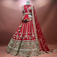 Red raw silk bridal lehenga set with tiered embroidered hem and two net dupattas on mannequin