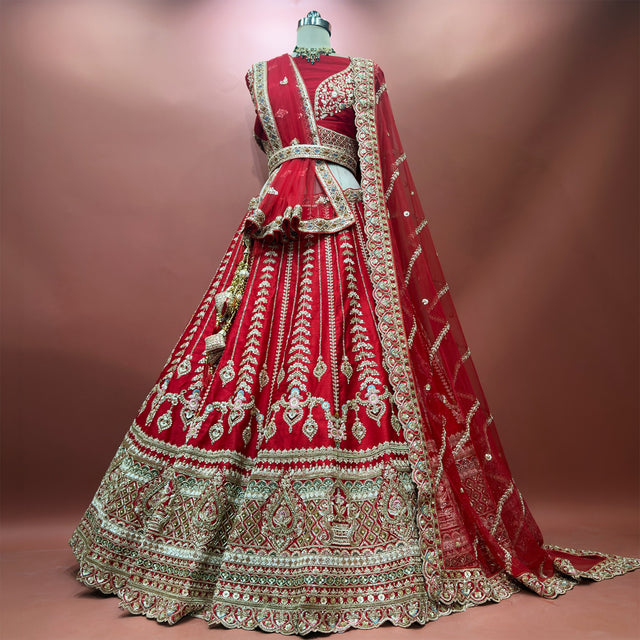 Red raw silk bridal lehenga set with tiered embroidered hem and two net dupattas on mannequin