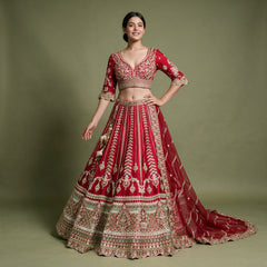 Red raw silk bridal lehenga with leaf-vine columns, embroidered V-neck blouse and net dupatta, worn