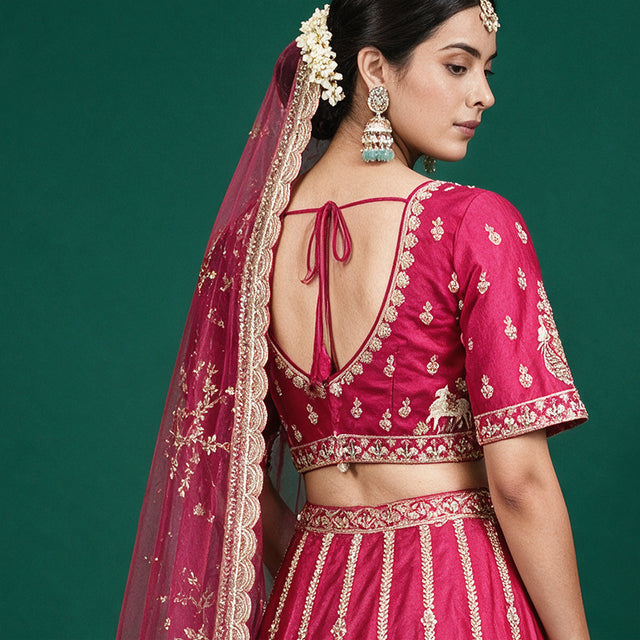 Rani pink bridal lehenga top with open back tie, gold embroidery, and sheer dupatta