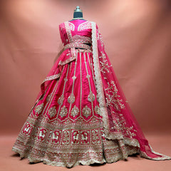 Rani pink raw silk bridal lehenga with gold zari kalis, cow motif hem border and net dupatta