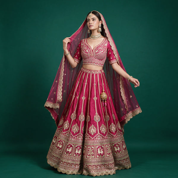 Rani pink bridal lehenga with gold border, cow-motif trim, and double net dupatta