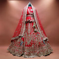 Red raw silk bridal lehenga with elephant and rider procession embroidery and two net dupattas draped as a veil