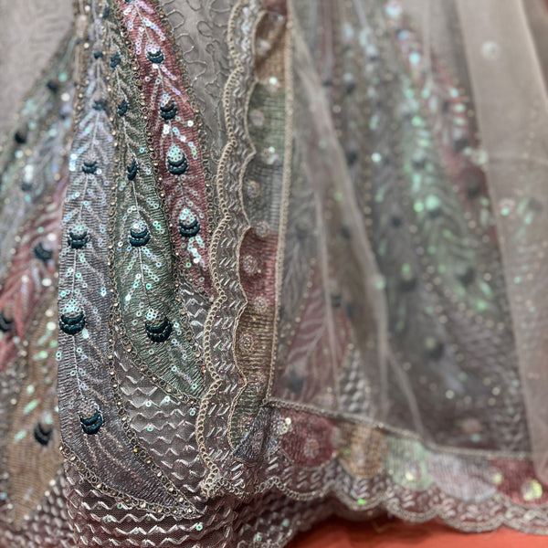 Close-up of grey sequin embroidery with peacock feathers on net lehenga