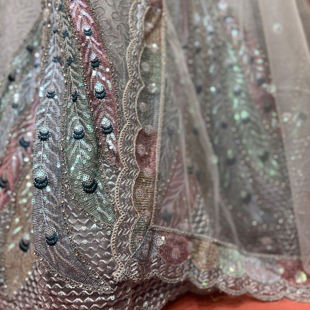 Close-up of grey sequin embroidery with peacock feathers on net lehenga
